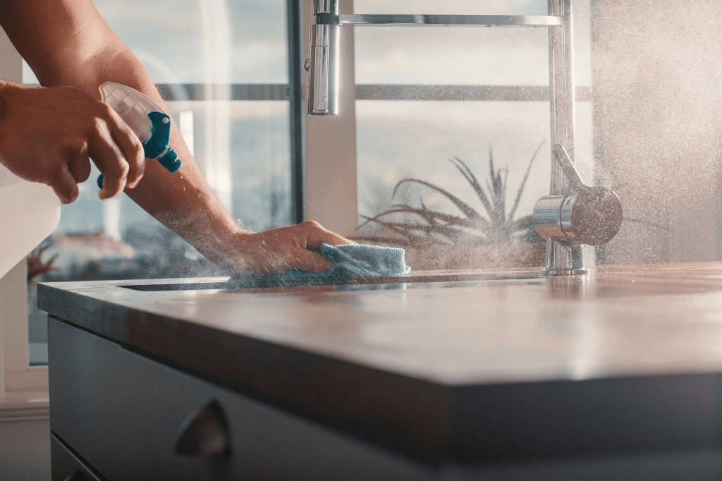 Hands wiping down a kitchen counter during a cleaning visit